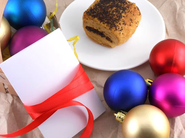 Kuchen mit Weihnachtskugeln und weißer Einladungskarte — Stockfoto