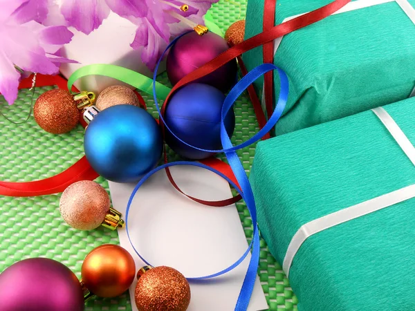 Una caja de regalo con una cinta blanca y bolas de año nuevo — Foto de Stock