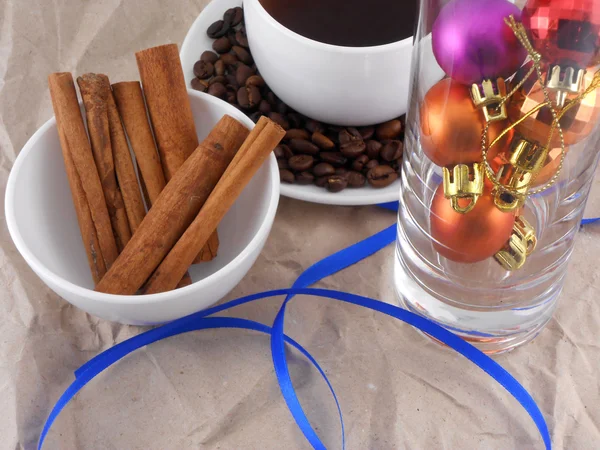 Tasse Kaffee mit Zimt, Kaffeebohnen und Weihnachtskugeln — Stockfoto