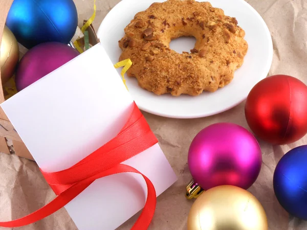 Kuchen mit Weihnachtskugeln und weißer Einladungskarte — Stockfoto