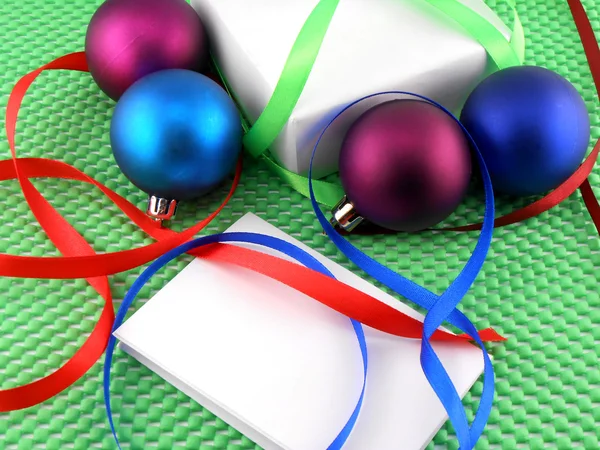 Christmas balls, white gift box and white invitation card — Stock Photo, Image