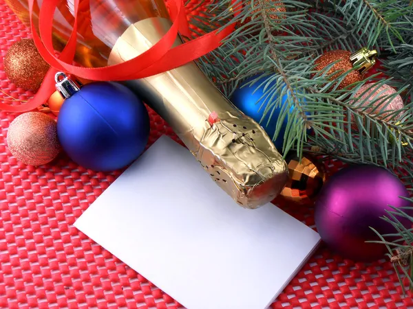 Botella de champán con bola de Navidad y cinta roja, tarjeta de invitación — Foto de Stock