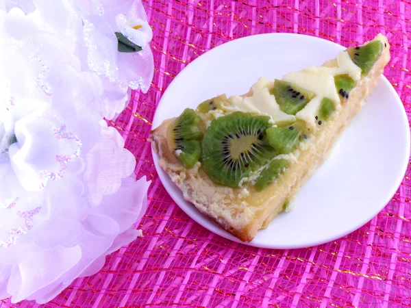 Quivi bolo saboroso perto na chapa com flores brancas — Fotografia de Stock