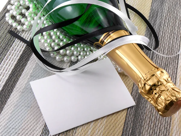 Champagne bottle with christmas present, holiday invitation card — Stock Photo, Image