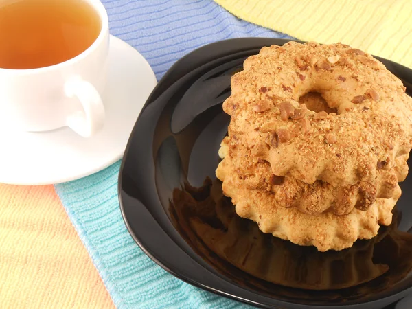 Tazza di tè con biscotti dolci sul piatto primo piano — Foto Stock