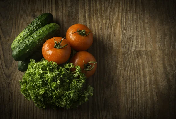 Los tomates rojos y el pepino sobre el verdor verde — Foto de Stock