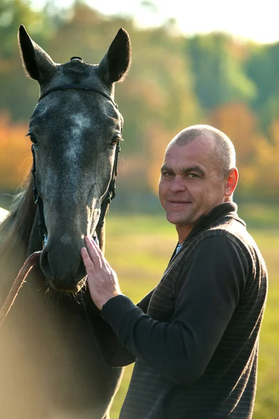 Muž chodí s koněm — Stock fotografie