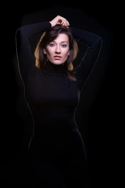 Güzel bir genç kadın siyah bir arka plan — Stok fotoğraf