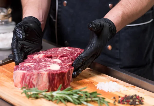 Nötkött Bitar Brädet Och Mänskliga Händer — Stockfoto