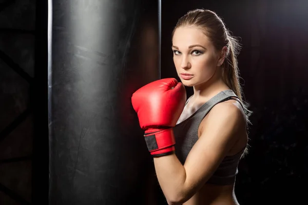 Mujer Joven Cerca Del Saco Boxeo Sobre Fondo Oscuro —  Fotos de Stock