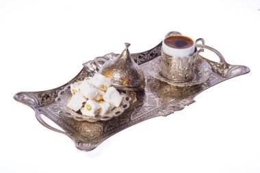 Tarafsız beyaz arka planda gümüş tepside Türk lokumu ve kahvesi.