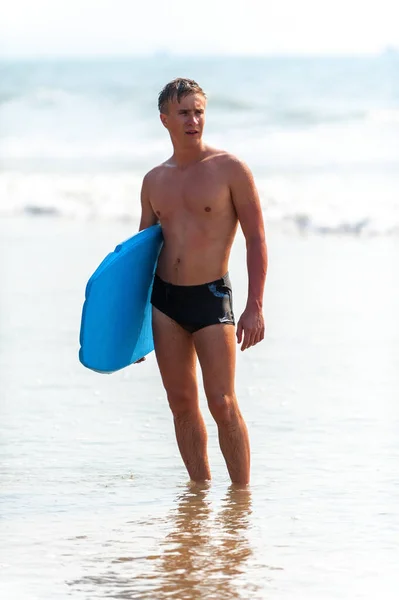 海岸にボードを持つ若い男 — ストック写真