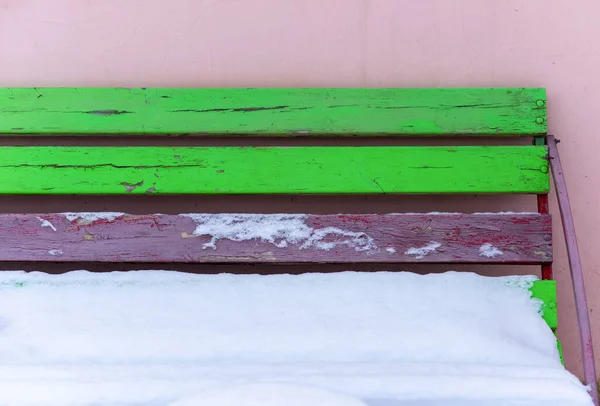 雪が降る色の木のベンチ — ストック写真