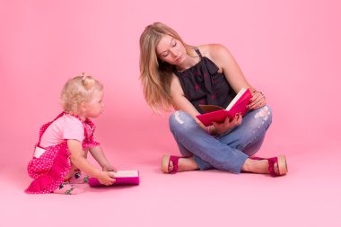 Anne ve kızı kitap okuyorlar.