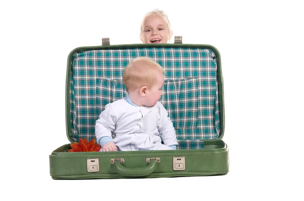 น้องสาวและพี่ชาย นั่งอยู่ในกระเป๋าเดินทางสีเขียวเก่า — ภาพถ่ายสต็อก