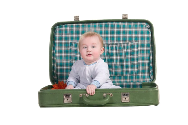 Child sitting in an old green suitcase in anticipation of travel — Stock Photo, Image