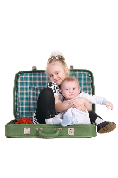 Sister and brother, sitting in an old green suitcase — Stock Photo, Image