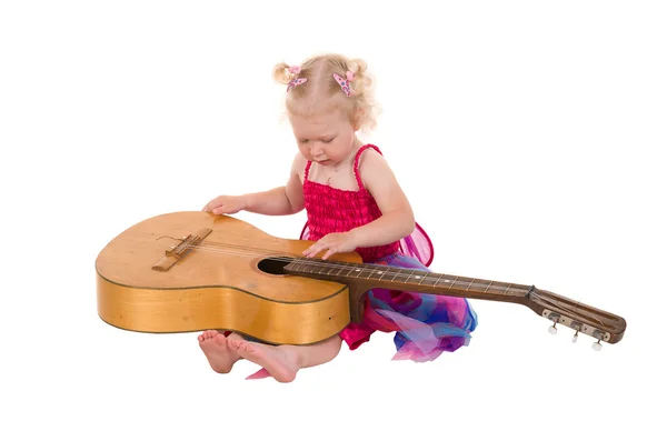 Little girl in a pink dress playing guitar — Stock Photo, Image