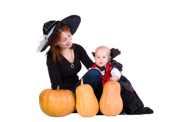 Baby boy and mother in black halloween cloak playing with pumpk — Stock Photo, Image