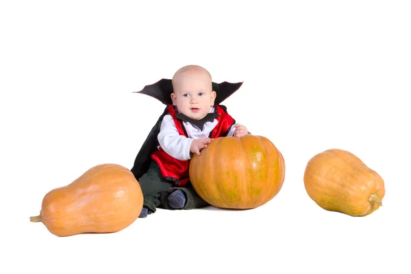 Baby boy in black halloween cloak with pumpkins — Stock Photo, Image