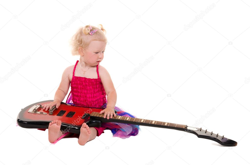 Little girl in a pink dress playing guitar