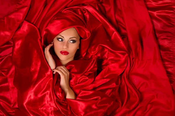 Sensual face in red satin fabric — Stock Photo, Image