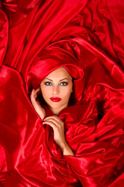 赤いサテンの布で官能的な顔 — ストック写真