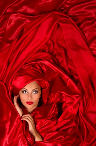 Sensual face in red satin fabric — Stock Photo, Image