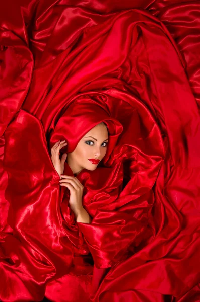 Sensual face in red satin fabric — Stock Photo, Image