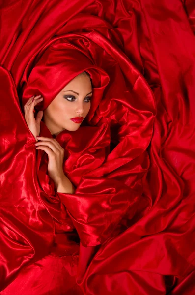 Sensual face in red satin fabric — Stock Photo, Image