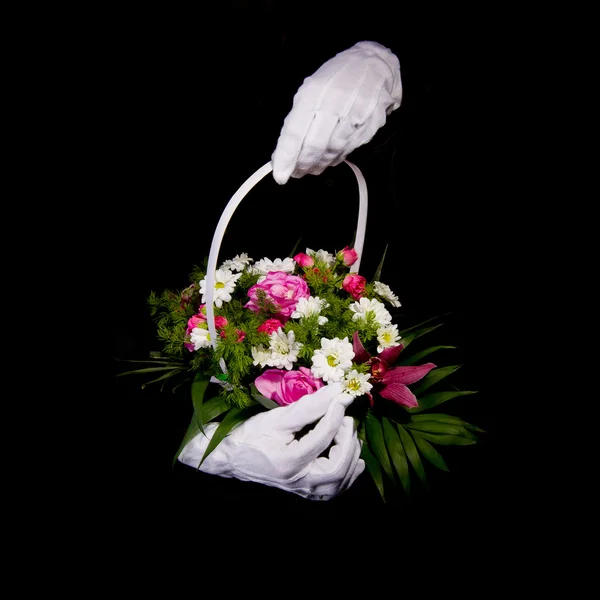 Manos en guantes blancos hacen cesta de flores —  Fotos de Stock
