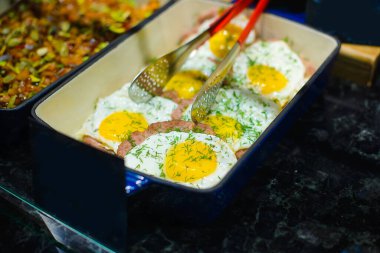 Sebzeli ve sahanda yumurtalı biftekler kantindeki yemek tepsisinde servis edilmeye hazır.