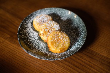 Kahverengi ahşap arka planda tatlı peynirli krep.