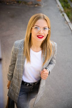 Gözlüklü, ceketli ve kırmızı rujlu güzel iş kadını.