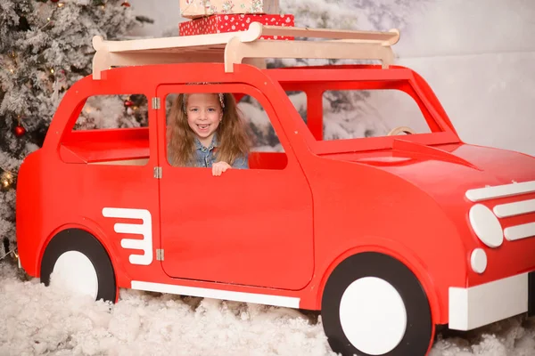 Menina Feliz Senta Carro Madeira Brinquedo Vermelho Olha Para Fora — Fotografia de Stock