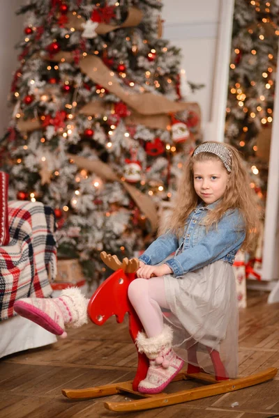 Boldog Lány Egy Piros Játék Hintaló Egy Szobában Egy Karácsonyfa — Stock Fotó