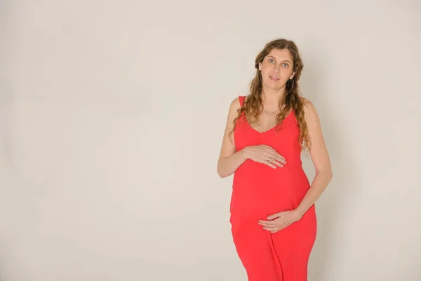 Retrato Uma Mulher Grávida Vestido Vermelho Fundo Estúdio Cinza Claro — Fotografia de Stock