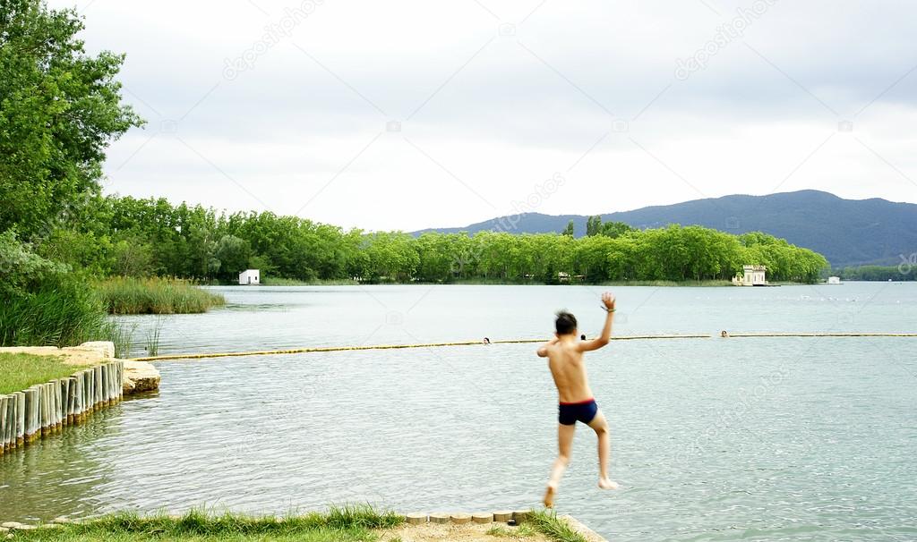 Child jumping to Bañolas's lake