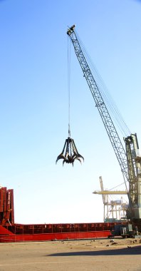 Crane octopus for unload of scrap in a wharf of the port of Barcelona clipart