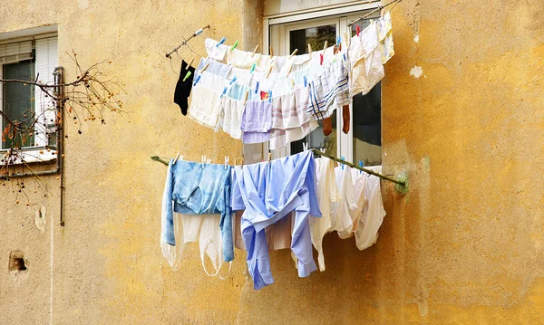 Roupas esticadas na frente de um edifício — Fotografia de Stock