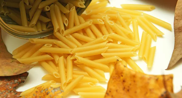 Lata macaroni auf dem Hintergrund der Blätter — Stockfoto
