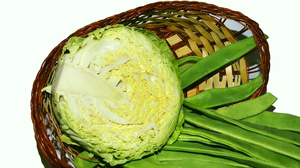Корзина с капустой и зеленой фасолью на белом фоне — стоковое фото