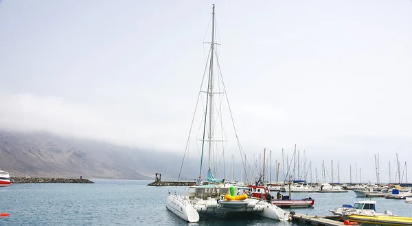 Hamn, båtar, bryggor och vågbrytare skulptur i isla la graciosa — Stockfoto