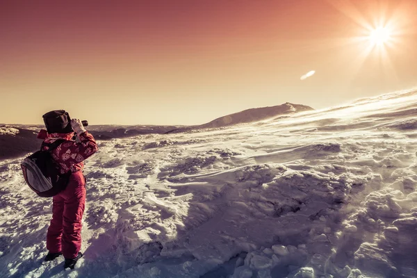 Turista mirando a través de prismáticos en las laderas nevadas del Ca — Foto de Stock