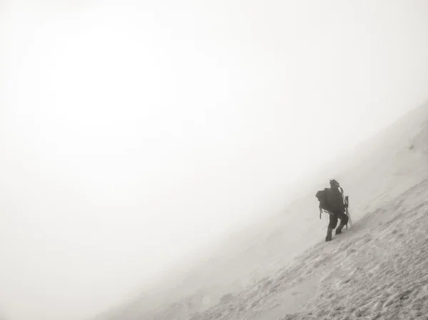 Bergsteiger klettert auf einen vereisten Hügel — Stockfoto