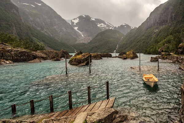 Barco solitario en el lago en las duras montañas —  Fotos de Stock