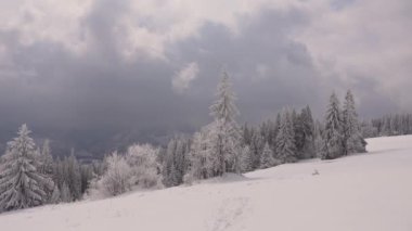 Romantik kış manzarası. Orman ve kardaki dağlar. Yavaşça hareket eden bulutlar