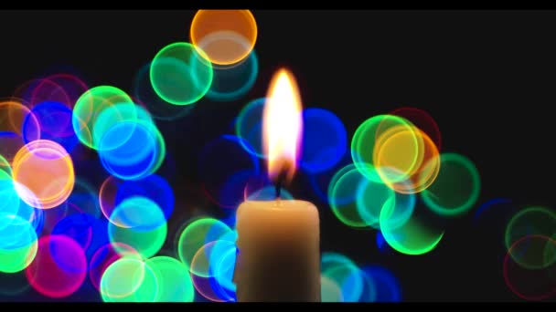 Romantische Kerze Auf Schwarzem Hintergrund Mit Blinkenden Bunten Lichtern — Stockvideo