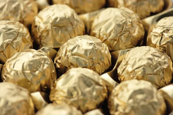 Chocolate sweets in golden foil — Stock Photo, Image