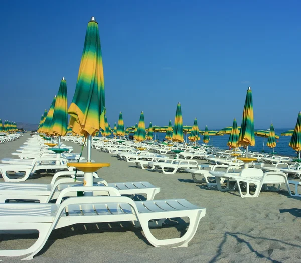 Beach with folded umbrellas — Stock Photo, Image